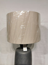 The Adesso Lamp Skylar Table Lamp features a beige shade on a black base, ideal for modern industrial spaces.