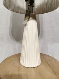 A cream pleated Lana 2 Pack Table Lamp by Adesso Lamp with oatmeal linen shade sits on a round light wood surface.