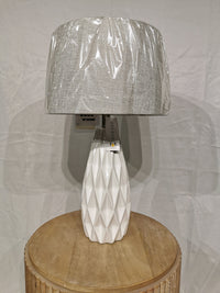 The Adesso Lamp Joan 2 Pack Table Lamp with ceramic base and gray shade is on a round wooden table.