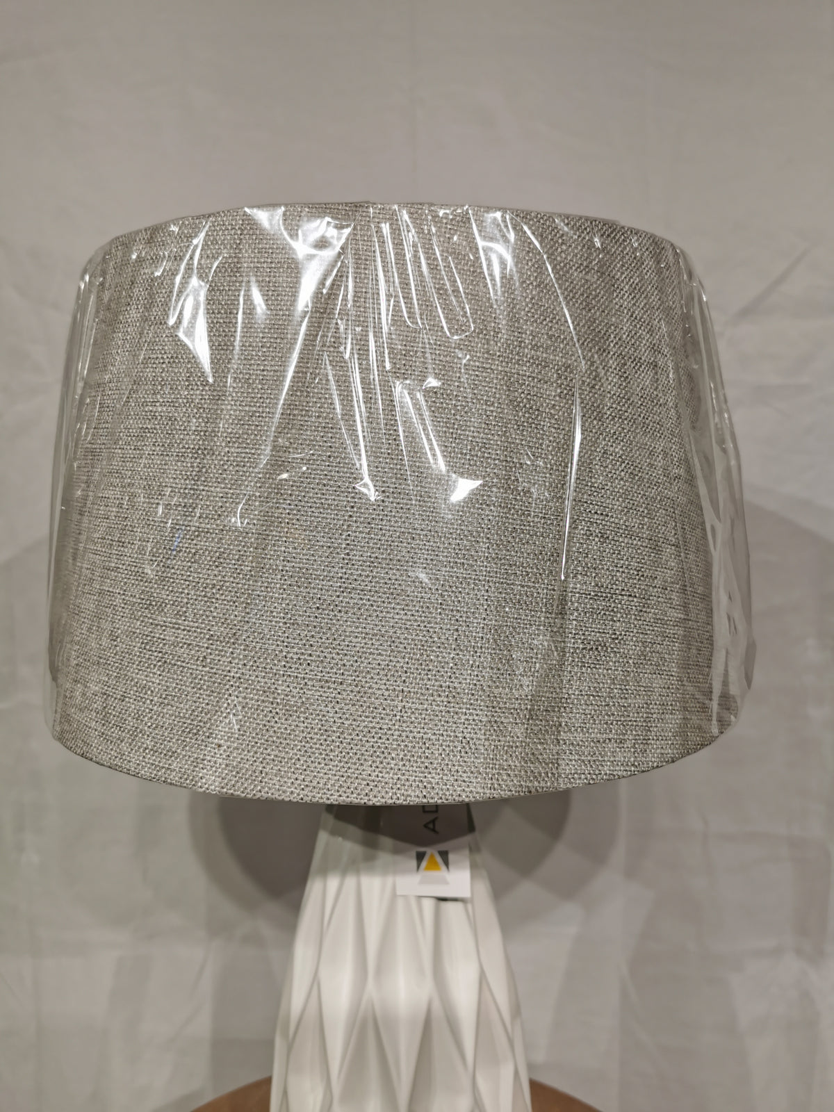 The Adesso Lamp Joan 2 Pack Table Lamp features a ceramic base and fabric shade with protective plastic, shown on plain background.