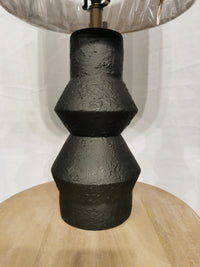 The Noelle Table Lamp by Adesso features a black textured ceramic base, wood accents, and a fabric shade.