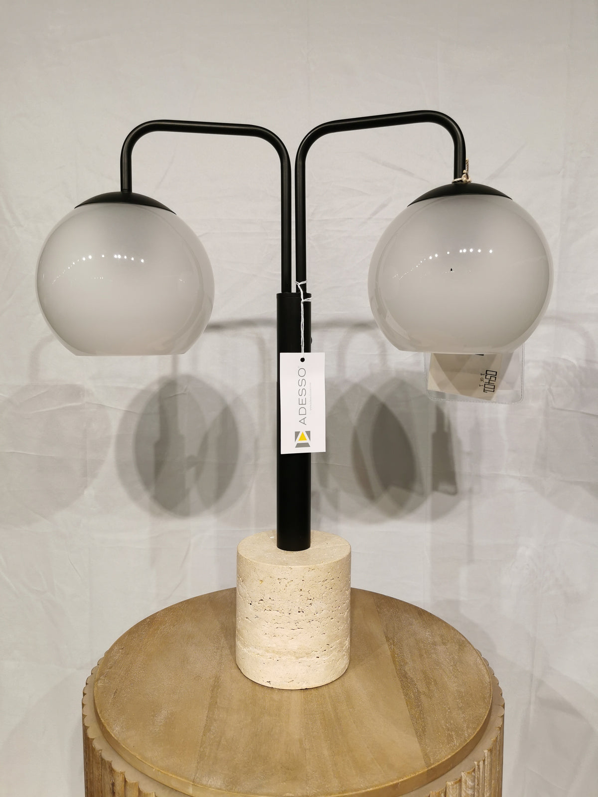 The Adesso Stockton Table Lamp has white glossed glass shades and a black finish on a round stone base.