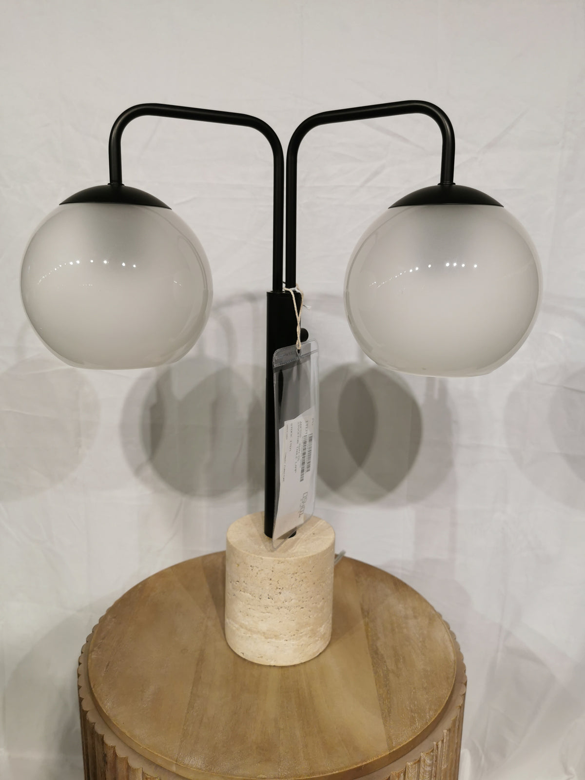 The Adesso Stockton Table Lamp has white glossed glass shades, a black finish, and a sleek cylindrical stone base.