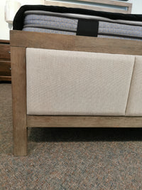 Close-up of the Donald Choi Winston Bed Frame, a modern bed with beige panels and mattress on a carpeted floor.