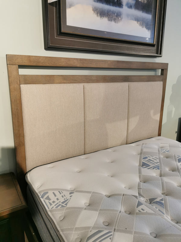 The Winston Bed Frame by Donald Choi features a cushioned beige headboard and patterned mattress under wall art.