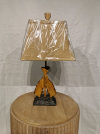The Crestview Collection Oar Accent Table Lamp, with a burlap shade, embodies a boating style on a wooden table.