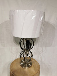 The Crestview Collection Metal 30" Table Lamp features a chrome and white fabric shade with interlocking rings.
