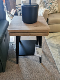 The Magnussen Fletcher End Table, T5864, with a driftwood finish and black lamp, enhances the living room aesthetic.