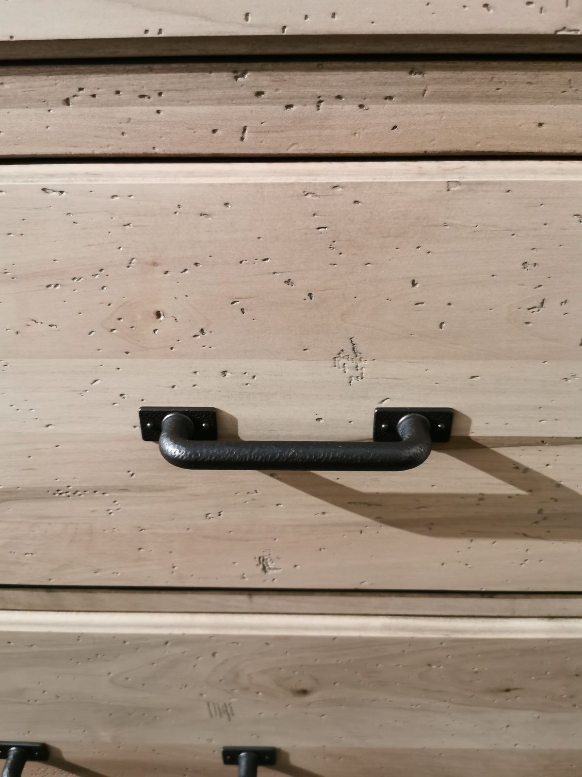 Close-up of a Vaughan Bassett 176 Cool Rustic Dresser drawer, featuring a black metal handle and textured wooden charm.