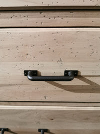 Close-up of a Vaughan Bassett 176 Cool Rustic Dresser drawer, featuring a black metal handle and textured wooden charm.