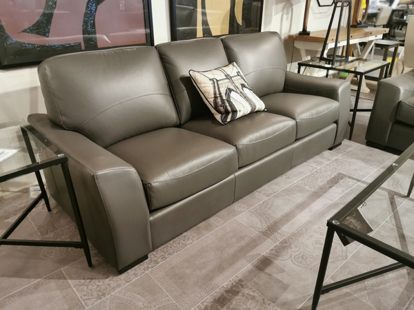 Kent Sofa (Armani Grey) by Leather Craft with a patterned pillow, paired with two glass-top side tables—perfect for any space.