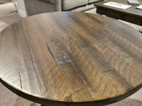 Close-up of a rustic 2491 Bellamy Round Accent Table by Magnussen, featuring a textured surface with grain patterns.