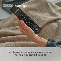 A hand holds a remote over a beige blanket, highlighting Beauty-Rest's Platinum Adjustable Base with whisper-quiet dual massage.