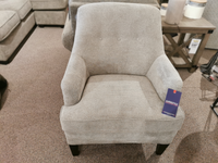 A Superstyle 31-03 Chair: Dason Stone in light gray with a blue sale tag is on a carpeted showroom floor.