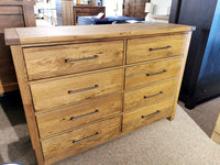 The 752 Dovetail 8-Drawer Dresser by Vaughan Bassett, made of American White Oak, is showcased with metal handles.