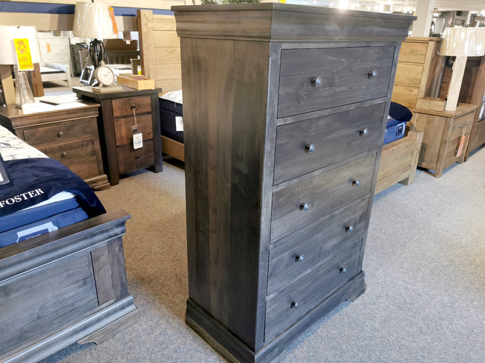 The Vokes 462 Bayshore 5-Drawer Chest with ebony finish is displayed in a furniture showroom.