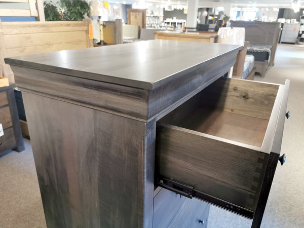 The Vokes 462 Bayshore 5-Drawer Chest with one top drawer open is displayed in a furniture showroom.