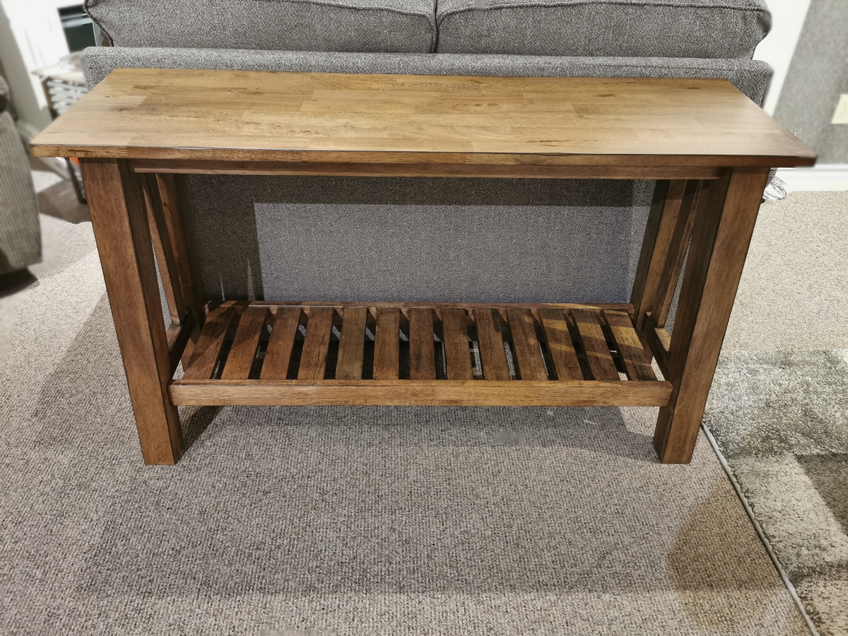 The NP100S Newport Sofa Table by Winners Only features a distressed finish and slatted shelf, perfect behind your sofa.