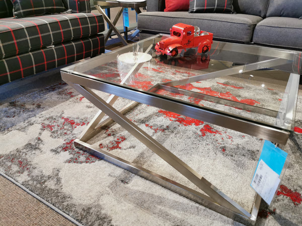 Ashley Coylin Coffee Table with angled base on a patterned rug, featuring a small red toy truck and white decorative bowl.