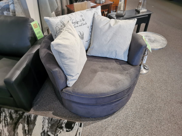 Displayed in the furniture store, the Decor-rest 2991 Swivel Chair 46" is a round gray chair featuring two white cushions and adorned with sale tags, making it an ideal choice for style enthusiasts seeking something unique and customizable.