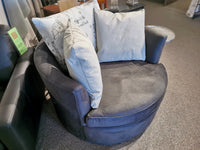 Round 46" Decor-rest 2991 Swivel Chair in gray, featuring two beige pillows and one print pillow, showcased on a carpeted floor. Custom order options are available.