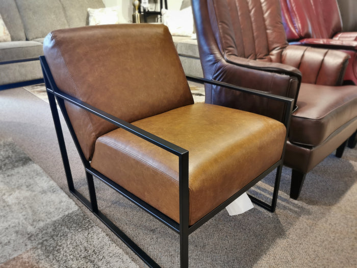 The 3071 Chair by Decor-rest features a modern brown leather upholstery and a black metal frame that exudes mid-century design, perfect for display in a furniture store setting.