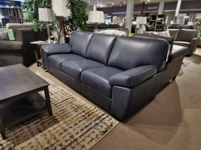 The Leather Craft Manchester Sofa, in black top-grain leather with three cushions, is shown beside a wooden coffee table.