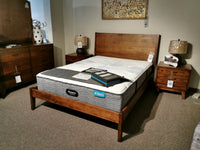 The Vokes Rocklynd Queen Bed is displayed with mattress, flanked by matching nightstands and lamps.