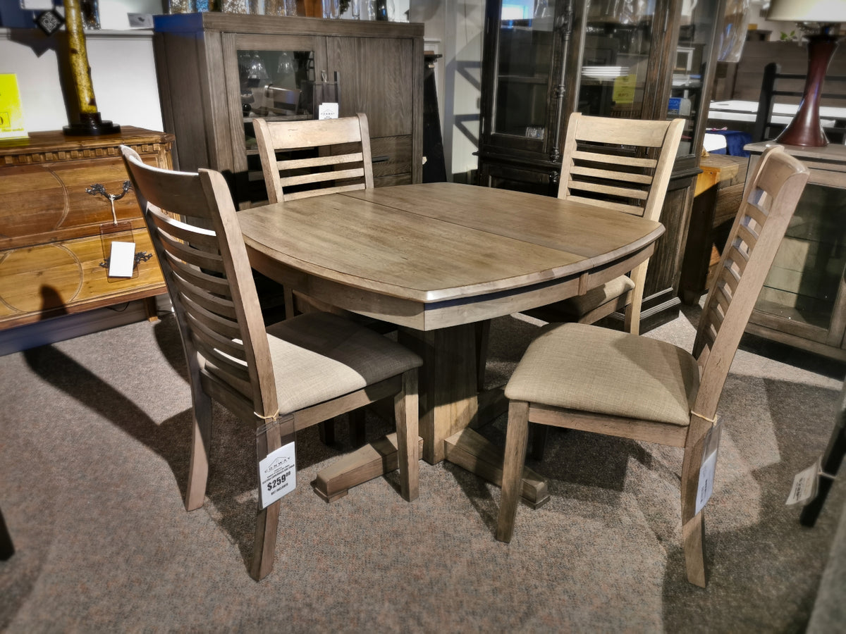 The Winners Only Ventura Pedestal Table with 4 matching chairs in a grey wash is displayed in the showroom.