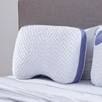A Bed Gear Balance Cuddle Pillow with Air-X mesh sits upright against a gray upholstered headboard.