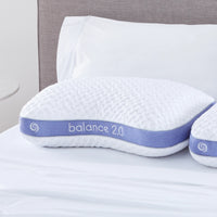 A Bed Gear Balance Cuddle Pillow with Air-X mesh and a purple band sits on a bed with crisp white linens.