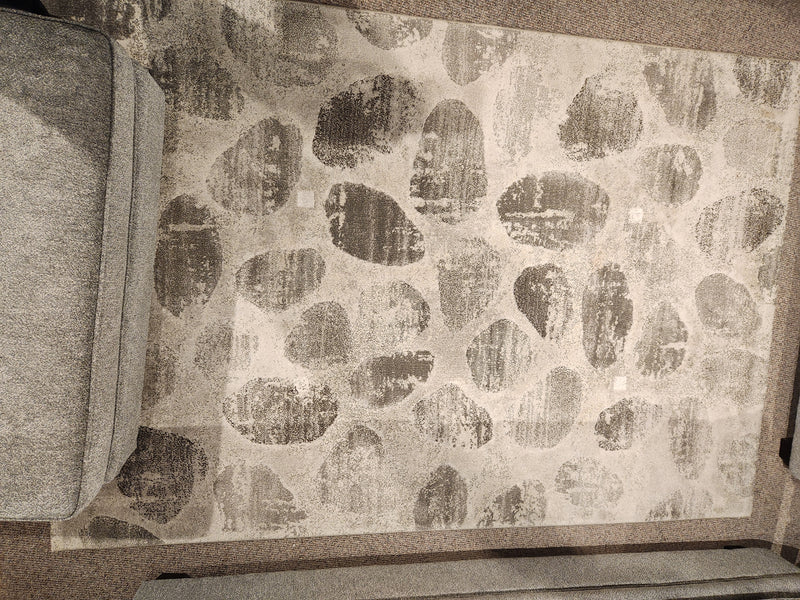 A Kalora Flint 6279/6S13 beige and gray area rug sits between two gray upholstered couches.