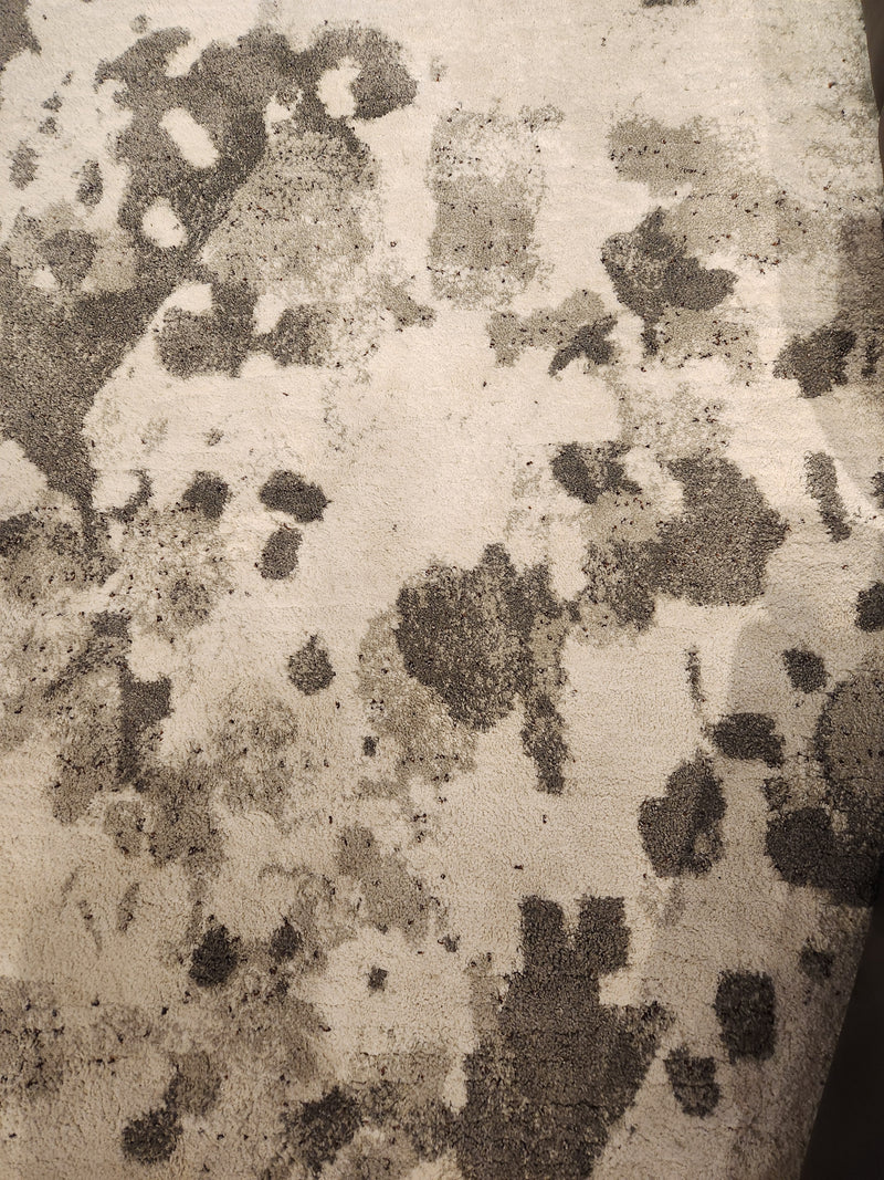 A close-up of the Kalora Ravine A571/AP01 5'3" x 7'7" area rug, showing its grey blotch pattern on a light base.