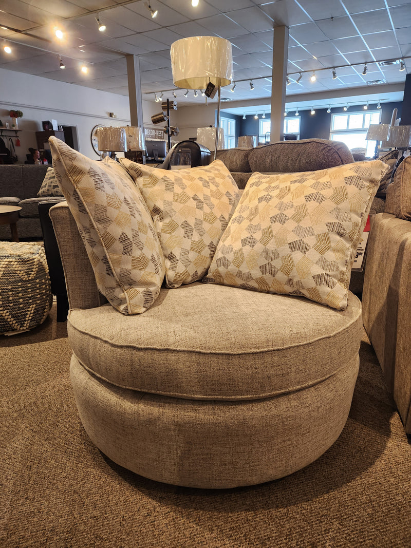 The Superstyle 373-59 Swivel Chair is a round beige modern seat with three patterned cushions on showroom display.