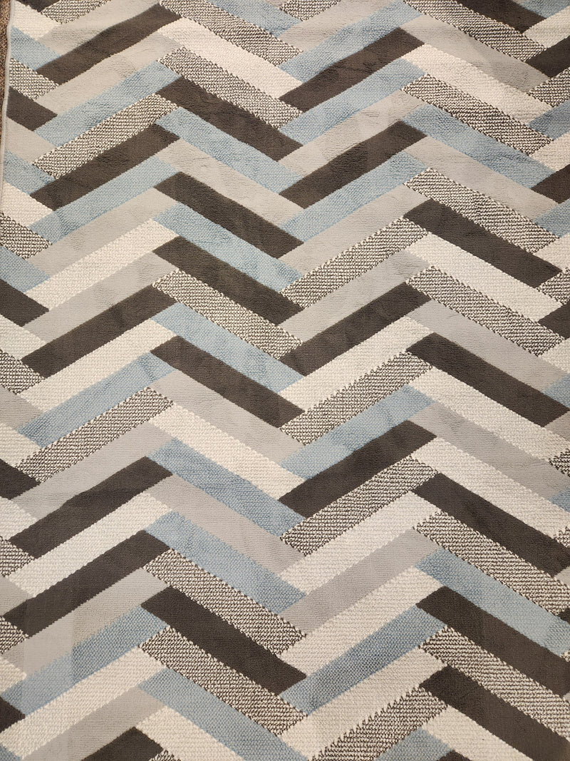 The Kalora Faira 4046/5842 Area Rug features a durable chevron pattern in gray, blue, black, and white.