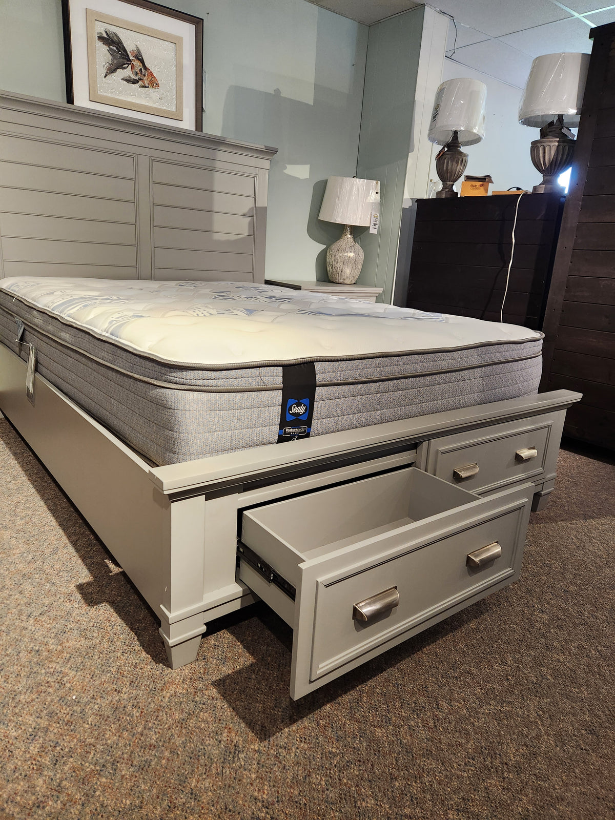 A Charleston bedroom with a gray Magnussen B5611 bed, mattress, and two lamps exudes a transitional aesthetic.