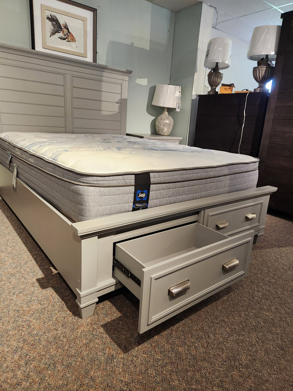 A Charleston bedroom with a gray Magnussen B5611 bed, mattress, and two lamps exudes a transitional aesthetic.