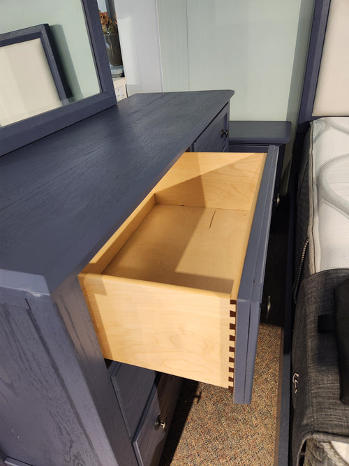 The Vaughan Bassett Artisan & Post dresser in White Oak has a drawer open, showing its light wood interior.
