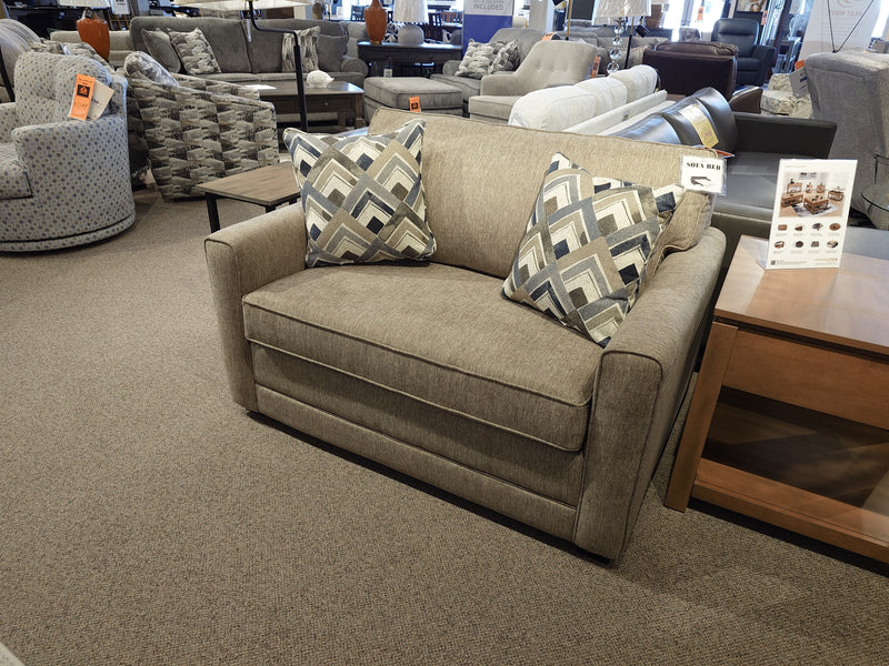 The Simmons Upholstery 1014 Trinity Chair Bed in beige includes two patterned pillows and a sleeper feature.