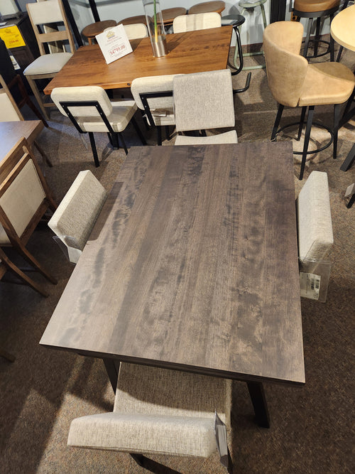 Amisco's Alex 36"x 60" dining set includes a scratch-resistant table and four upholstered chairs in a furniture store display.