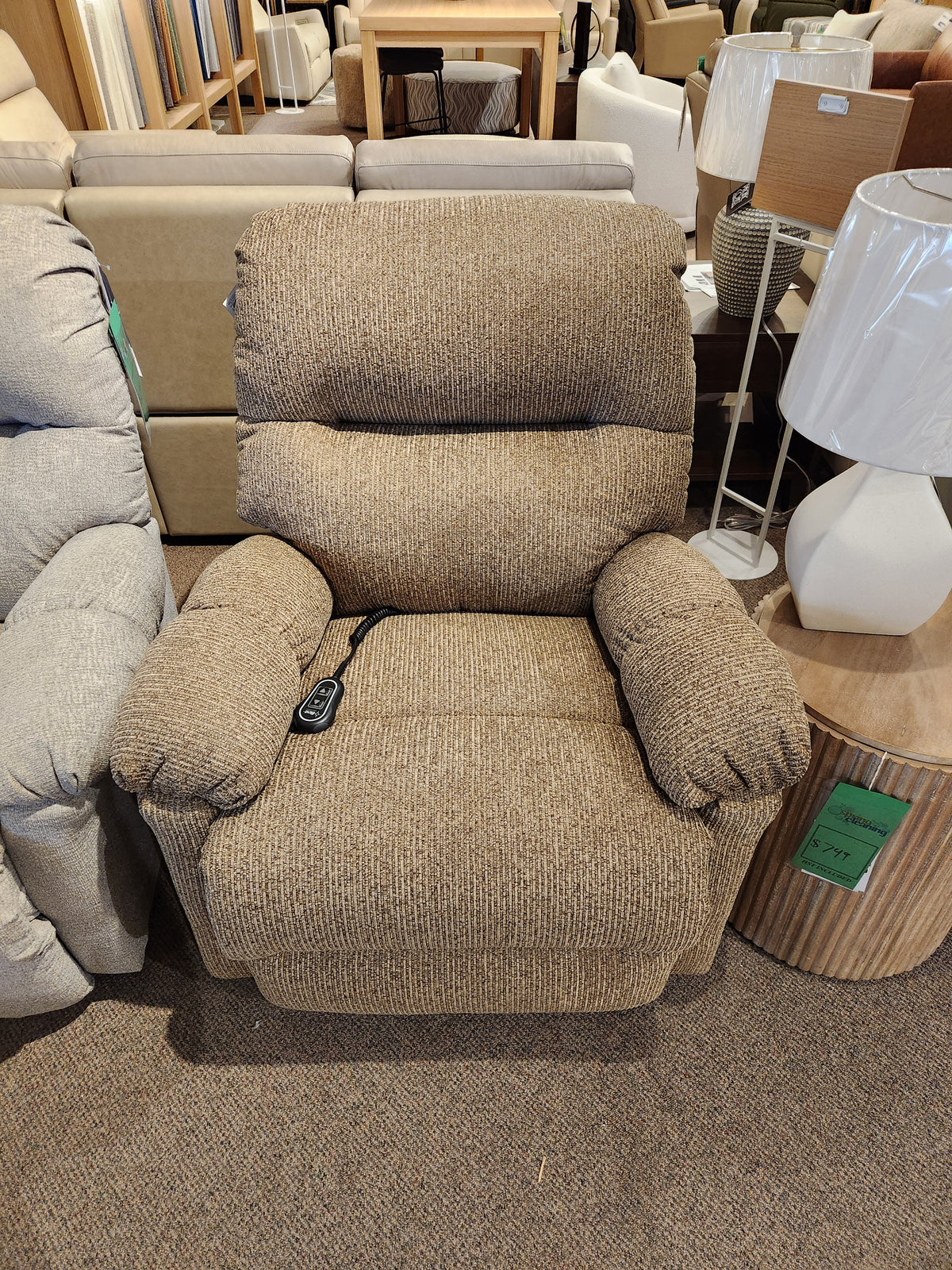The Best 7MP84 Ellisport Power Space Saver Recliner with remote, in brown, is shown in a furniture showroom.
