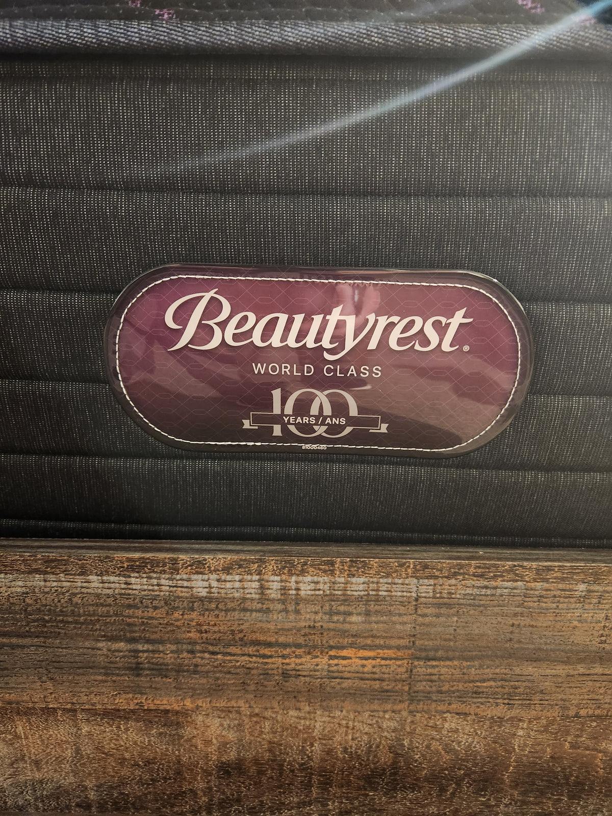 A Beauty-rest ESME TT Medium Mattress label is shown on a wooden bed frame, promising restful sleep nightly.