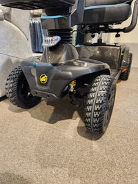 Close-up of the front wheels and base of the Golden Companion Full-Size Mobility Scooter on a carpeted floor.