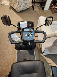 Top view of Golden Companion Full-Size Mobility Scooter dashboard with controls, display, mirrors & basket on carpet.