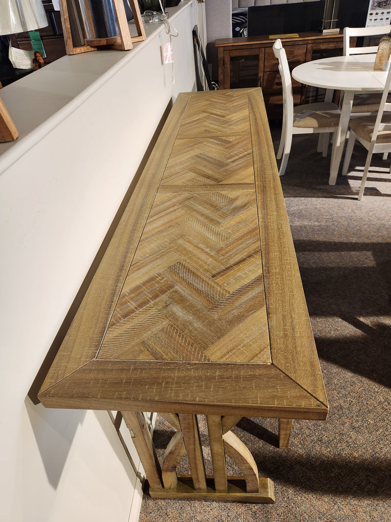The Jofran 1933-74 Fairview Counter Table with 3 Stools features a chevron top, displayed against a white wall in-store.