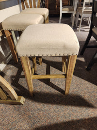 The Jofran 1933-74 Fairview Counter Table with 3 Stools features linen-blend upholstery and metal stud accents.