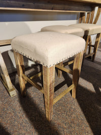 The Jofran 1933-74 Fairview Counter Table with 3 Stools features linen-blend seats and metal accents on carpet.
