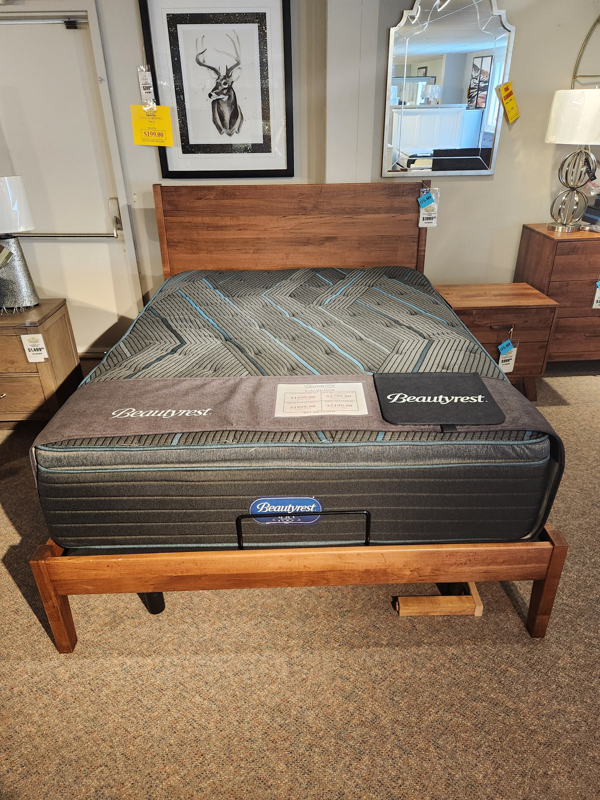 A Beauty-rest Echo PT Medium Mattress on a wooden frame in a stylish showroom.