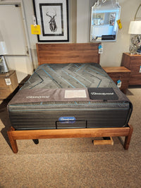 A Beauty-rest Echo PT Medium Mattress on a wooden frame in a stylish showroom.