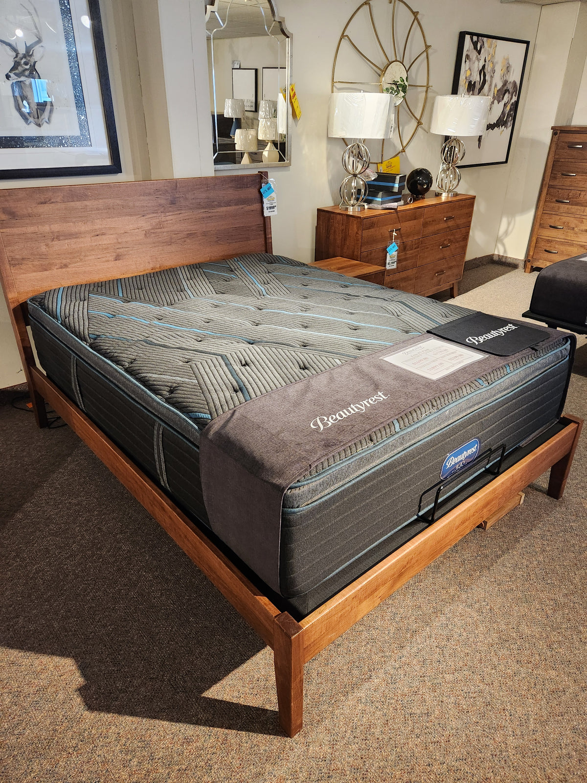 A Beauty-rest Echo PT Medium Mattress by Beauty-rest on a wooden bed frame in a stylish showroom.